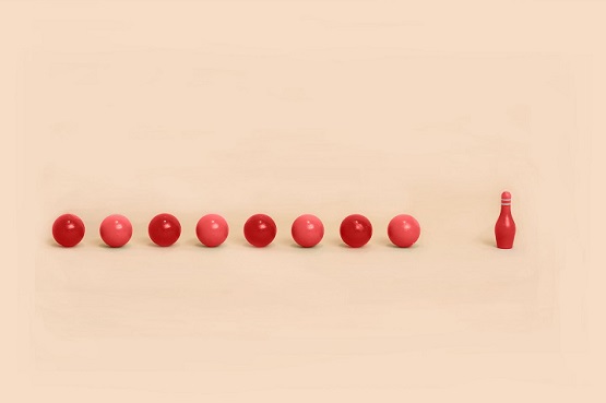 Orange bowling balls headed towards bowling pin