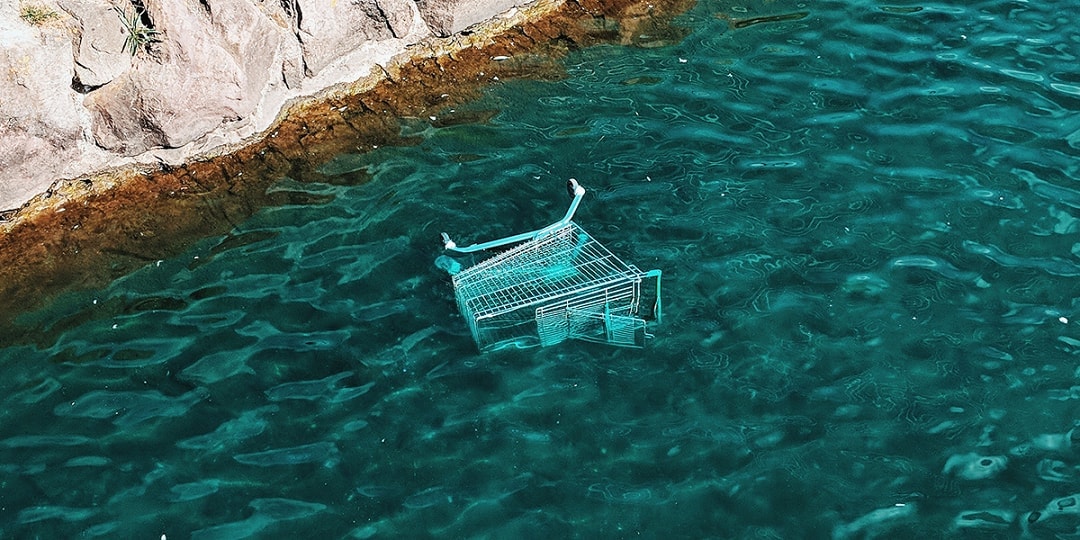 Shopping cart sinking in blue water