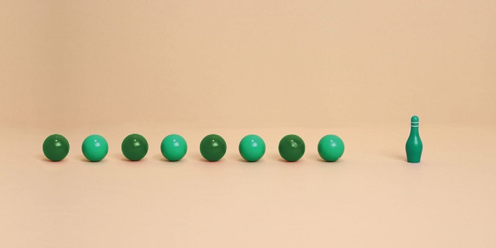 Green bowling balls headed towards bowling pin